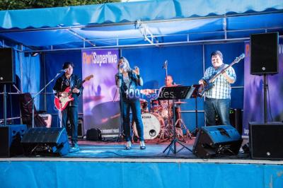 Un musicien joue du saxophone lors d'une réception festive dans une salle décorée avec des lumières et des drapés.