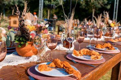 Table élégamment dressée avec verres, bougies allumées et compositions florales dans un cadre lumineux.