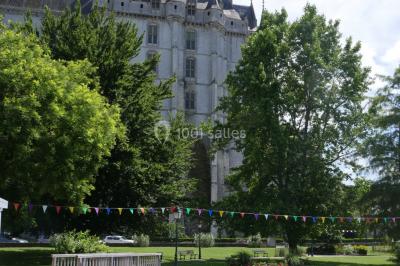 Étang bordé d'arbres avec des nénuphars à la surface et un petit pont en pierre sur la droite.