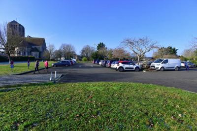 Cuisine professionnelle avec plan de travail en inox, cuisinière, évier, hotte et équipements muraux dans un espace carrelé.