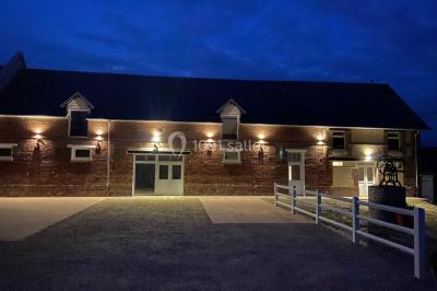 Miniature Location salle Morgny (Eure) - Domaine du Beauthil #4 Espace extérieur éclairé de nuit avec une pergola, des guirlandes lumineuses et des lanternes au sol.