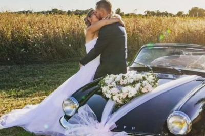 Bouquet de fleurs blanches et vertes au premier plan, avec des chaises disposées en extérieur sous un grand arbre.