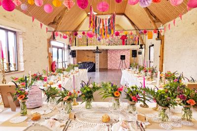 Bouquet de fleurs blanches et vertes au premier plan, avec des chaises disposées en extérieur sous un grand arbre.