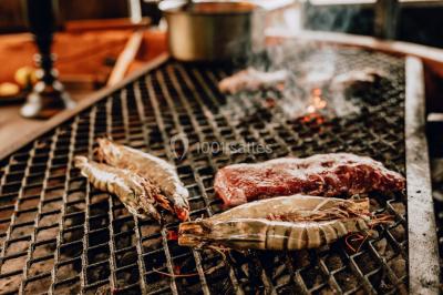 Terrasse extérieure animée avec tables, guirlandes lumineuses, vue sur un lac et montagnes en arrière-plan.