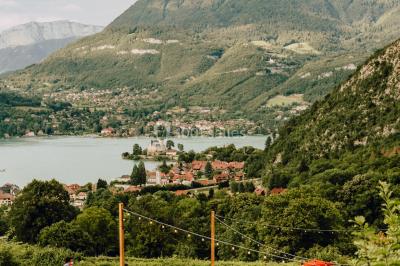 Vue nocturne d'un paysage montagneux avec un village éclairé au loin et une terrasse illuminée au premier plan.