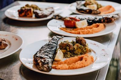 Vue nocturne d'un paysage montagneux avec un village éclairé au loin et une terrasse illuminée au premier plan.