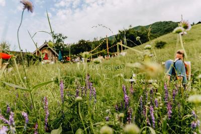 Vue nocturne d'un paysage montagneux avec un village éclairé au loin et une terrasse illuminée au premier plan.