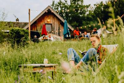 Vue nocturne d'un paysage montagneux avec un village éclairé au loin et une terrasse illuminée au premier plan.