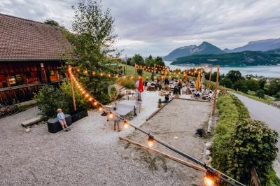 Vue nocturne d'un paysage montagneux avec un village éclairé au loin et une terrasse illuminée au premier plan.