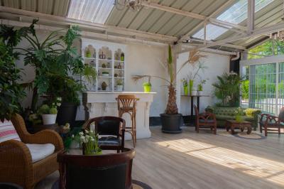 Salon avec fauteuils en cuir, table basse en bois, plante verte, bibliothèque et tableau sur un mur lambrissé.