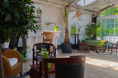 Salon avec fauteuils en cuir, table basse en bois, plante verte, bibliothèque et tableau sur un mur lambrissé.