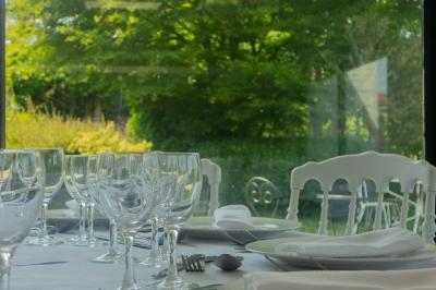 Salon avec fauteuils en cuir, table basse en bois, plante verte, bibliothèque et tableau sur un mur lambrissé.