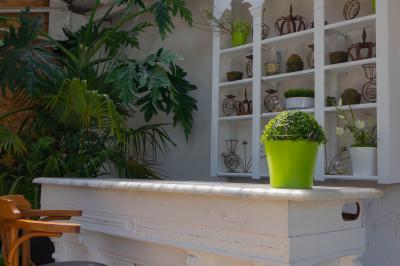 Salon avec fauteuils en cuir, table basse en bois, plante verte, bibliothèque et tableau sur un mur lambrissé.