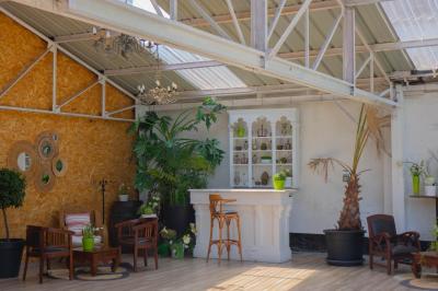 Salon avec fauteuils en cuir, table basse en bois, plante verte, bibliothèque et tableau sur un mur lambrissé.
