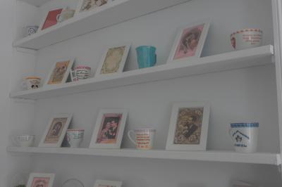 Salon avec fauteuils en cuir, table basse en bois, plante verte, bibliothèque et tableau sur un mur lambrissé.