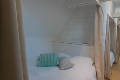 Salon avec fauteuils en cuir, table basse en bois, plante verte, bibliothèque et tableau sur un mur lambrissé.