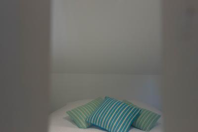 Salon avec fauteuils en cuir, table basse en bois, plante verte, bibliothèque et tableau sur un mur lambrissé.