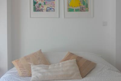 Salon avec fauteuils en cuir, table basse en bois, plante verte, bibliothèque et tableau sur un mur lambrissé.