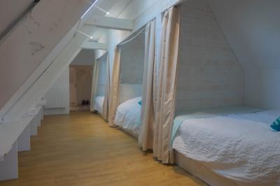 Salon avec fauteuils en cuir, table basse en bois, plante verte, bibliothèque et tableau sur un mur lambrissé.