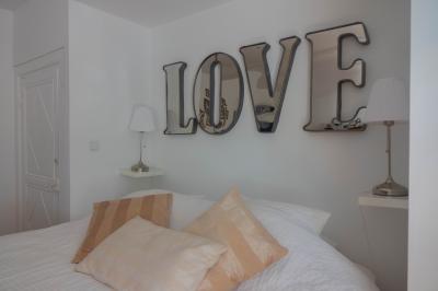 Salon avec fauteuils en cuir, table basse en bois, plante verte, bibliothèque et tableau sur un mur lambrissé.