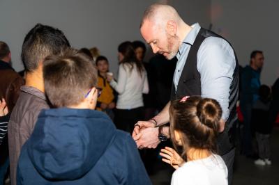 Un groupe de personnes assises et debout, riant et échangeant lors d'un moment convivial en extérieur.