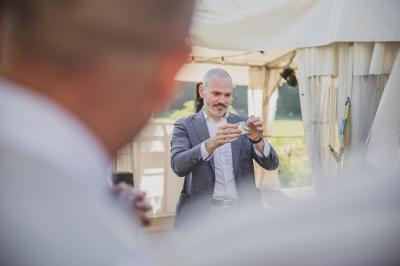Un groupe de personnes assises et debout, riant et échangeant lors d'un moment convivial en extérieur.
