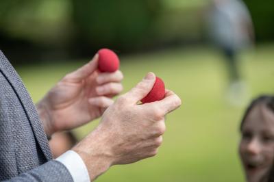 Un groupe de personnes assises et debout, riant et échangeant lors d'un moment convivial en extérieur.