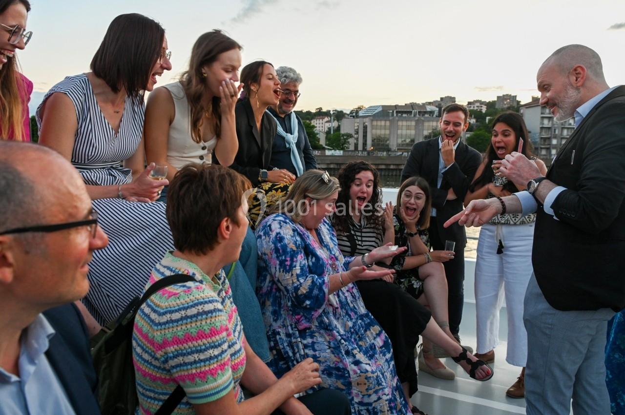 Un groupe de personnes assises et debout, riant et échangeant lors d'un moment convivial en extérieur.