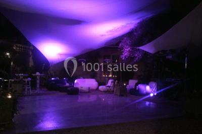 Vue aérienne d'un bâtiment historique entouré de jardins, de vignes et de maisons dans un paysage rural.