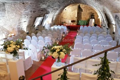 Vue aérienne d'un bâtiment historique entouré de jardins, de vignes et de maisons dans un paysage rural.