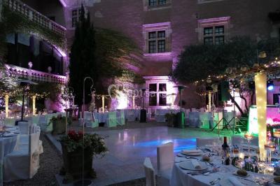Vue aérienne d'un bâtiment historique entouré de jardins, de vignes et de maisons dans un paysage rural.