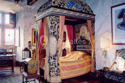 Vue aérienne d'un bâtiment historique entouré de jardins, de vignes et de maisons dans un paysage rural.