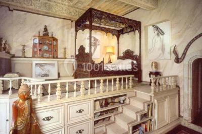 Vue aérienne d'un bâtiment historique entouré de jardins, de vignes et de maisons dans un paysage rural.