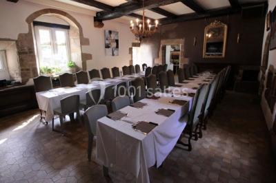 Piscine intérieure visible à travers une baie vitrée entourée de murs recouverts de plantes grimpantes, avec des tables…