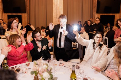 Un homme en costume verse une boisson depuis une tablette numérique dans un verre, illustrant un effet magique.