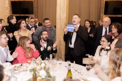 Un homme en costume verse une boisson depuis une tablette numérique dans un verre, illustrant un effet magique.