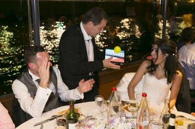 Un homme en costume verse une boisson depuis une tablette numérique dans un verre, illustrant un effet magique.