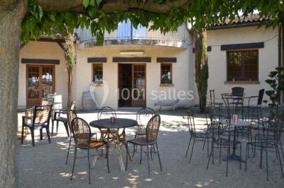 Table dressée avec nappes rouges, serviettes pliées, verres et assiettes, dans une salle lumineuse avec un serveur en…