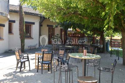 Table dressée avec nappes rouges, serviettes pliées, verres et assiettes, dans une salle lumineuse avec un serveur en…