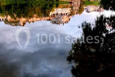 Miniature Location salle Amboise (Indre-et-Loire) - Les Ecuries du Signe #13 Reflet d'un château et de ses remparts dans une rivière calme, entouré de verdure et d'arbres au crépuscule.