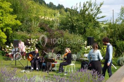 Miniature Location salle Neufchâtel-en-Bray (Seine-Maritime) - Le Cellier du Val Boury #19 Jardin fleuri avec des plantes variées devant une maison en briques et toit en tuiles, entourée d'arbres.