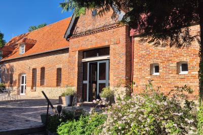 Miniature Location salle Neufchâtel-en-Bray (Seine-Maritime) - Le Cellier du Val Boury #11 Jardin fleuri avec des plantes variées devant une maison en briques et toit en tuiles, entourée d'arbres.