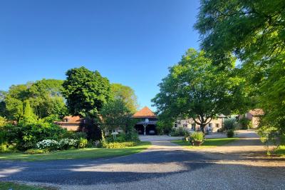 Miniature Location salle Neufchâtel-en-Bray (Seine-Maritime) - Le Cellier du Val Boury #7 Jardin fleuri avec des plantes variées devant une maison en briques et toit en tuiles, entourée d'arbres.