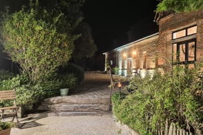Miniature Location salle Neufchâtel-en-Bray (Seine-Maritime) - Le Cellier du Val Boury #16 Jardin fleuri avec des plantes variées devant une maison en briques et toit en tuiles, entourée d'arbres.