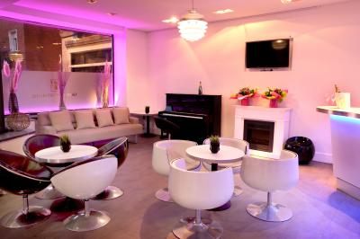 Salle de casino avec machines à sous lumineuses, écrans de jeux interactifs et un bar en arrière-plan.