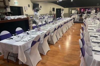 Salle de casino avec machines à sous lumineuses, écrans de jeux interactifs et un bar en arrière-plan.