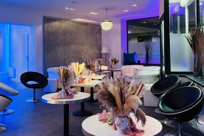 Salle de casino avec machines à sous lumineuses, écrans de jeux interactifs et un bar en arrière-plan.