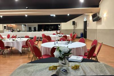 Salle de casino avec machines à sous lumineuses, écrans de jeux interactifs et un bar en arrière-plan.