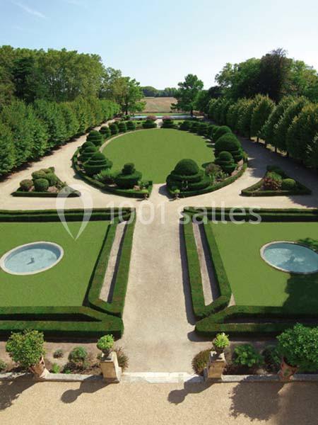 Jardin symétrique avec allées gravillonnées, haies taillées, pelouses géométriques et deux bassins circulaires.
