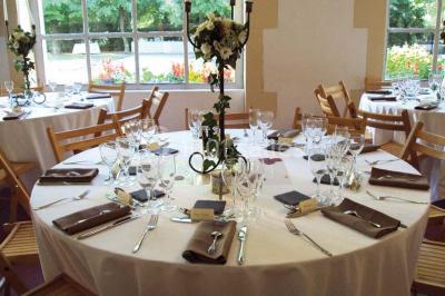 Un couple en tenue de cérémonie est transporté dans une calèche tirée par des chevaux sur un chemin bordé d'arbres.